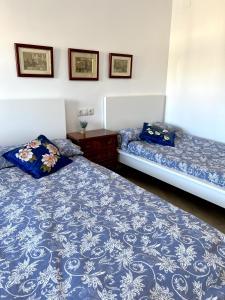 duas camas num quarto com lençóis azuis e brancos em Rare find! Skyline view-Modern 6 bed 2 bath flat in the heart of Málaga em Málaga