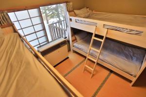 a small room with two bunk beds and a ladder at The VILLA ABASHIRI in Kawayu