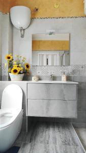 un bagno con lavandino, water e specchio di Capitan Shonny a Portoscuso
