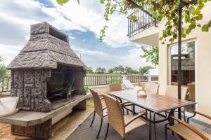a patio with a wooden table and a stone fireplace at Apartments and Rooms Michaela in Fažana
