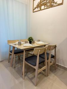 a wooden table with four chairs and a table and ahibition at Downtown Remin Suites at The Shore Kota Kinabalu in Kota Kinabalu