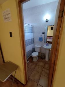 een badkamer met een toilet, een wastafel en een spiegel bij Hostal Km Zero El Huertillo in San Pedro de Atacama