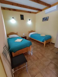 圣佩德罗·德·阿塔卡马Hostal Km Zero El Huertillo的一间房间里有两张床的卧室