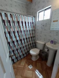 a bathroom with a toilet and a sink at Hostal Km Zero El Huertillo in San Pedro de Atacama