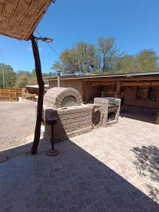 a brick oven in a patio with a building at Hostal Km Zero El Huertillo in San Pedro de Atacama