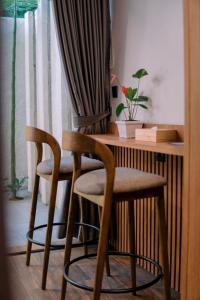 two chairs and a desk in a room with a window at Kaso Urban Villa in Yogyakarta