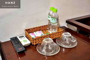 a bottle of water and two glasses and a remote control at HANZ SEN Hotel in Ho Chi Minh City