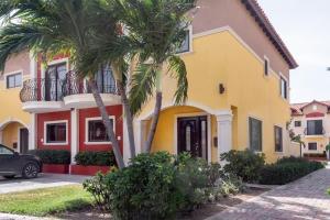 a yellow house with palm trees in front of it at The best house in gold coast 4 bedrooms in Palm-Eagle Beach