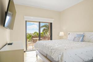 a white bedroom with a bed and a balcony at wonder apartment in gold coast with private pool in Palm-Eagle Beach