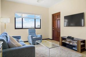 a living room with a couch and a tv at wonder apartment in gold coast with private pool in Palm-Eagle Beach