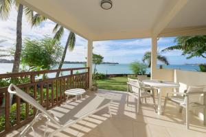 a porch with a table and chairs and the ocean at LAGOON VIEW Résidence in Grand-Baie