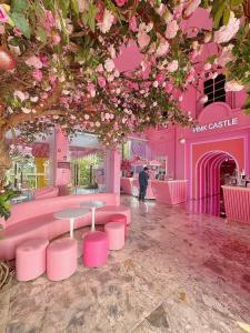 a pink room with pink tables and a tree at Flamingo Ibiza Hai Tien in Thanh Hóa