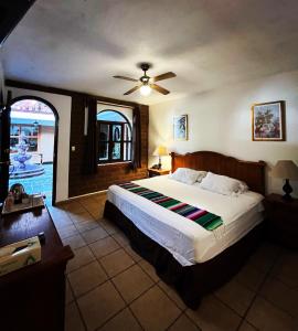 a bedroom with a large bed with a ceiling fan at Hotel Hacienda Ventana del Cielo in Tepoztlán