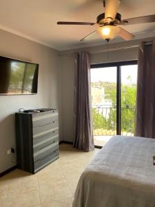 Schlafzimmer mit einem Bett, einem TV und einem Fenster in der Unterkunft Special house in gold coast with private jacuzzi in Palm-Eagle Beach