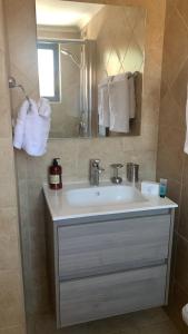 ein Badezimmer mit einem Waschbecken, einem Spiegel und Handtüchern in der Unterkunft Special house in gold coast with private jacuzzi in Palm-Eagle Beach