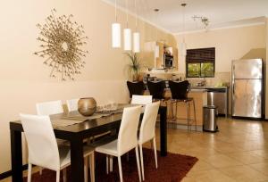 ein Esszimmer mit einem Tisch und weißen Stühlen in der Unterkunft Spectacular house in gold coast in Palm-Eagle Beach