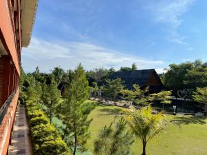 a view of a garden with a building and trees at GRAND MULYA HOTEL BOGOR in Sukaraja