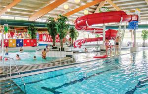 een zwembad met een glijbaan en mensen in het water bij Stunning Home In Vlagtwedde With Kitchen in Vlagtwedde