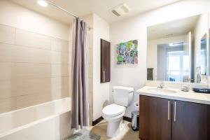 a bathroom with a toilet and a sink and a tub at 2BR Modern Luxury Condo WeHo in Los Angeles