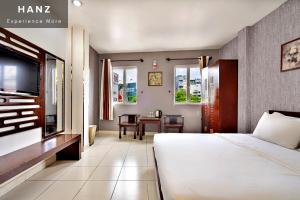 1 dormitorio con cama, mesa y TV en HANZ SEN Hotel Ben Thanh, en Ho Chi Minh