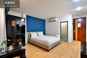 1 dormitorio con cama y pared azul en HANZ SEN Hotel Ben Thanh, en Ho Chi Minh