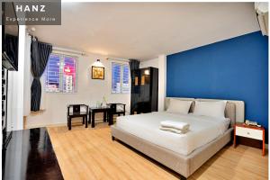 1 dormitorio con 1 cama grande y pared azul en HANZ SEN Hotel Ben Thanh, en Ho Chi Minh