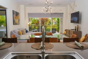 een keuken en een woonkamer met een wastafel en een tafel bij Modern apartment in levent in front of eagle beach in Palm-Eagle Beach