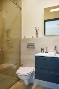 een badkamer met een toilet, een wastafel en een douche bij Modern apartment in levent in front of eagle beach in Palm-Eagle Beach