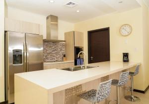 a kitchen with a counter with a sink and a refrigerator at Beautiful apartment in eagle beach levent in Palm-Eagle Beach