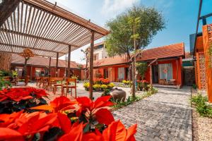 un jardín con flores rojas y un patio en TRUONG PHU HOUSE - HOTEL & APARTMENT en Hue