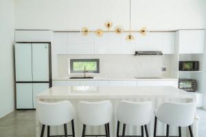 順化的住宿－Jade Hill Villa，厨房配有白色的柜台和白色的椅子