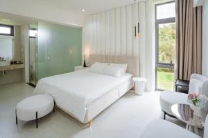 順化的住宿－Jade Hill Villa，白色卧室配有一张大床和一张桌子