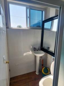 een kleine badkamer met een wastafel en een raam bij Habitación#1 Casa Rosita a metros del Lago in San Pedro La Laguna