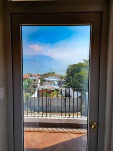 a door to a balcony with a view of a house at Habitación#1 Casa Rosita a metros del Lago in San Pedro La Laguna