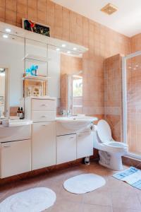 a bathroom with a white sink and a toilet at The elegance of Tierra del Sol with private pool in Palm-Eagle Beach