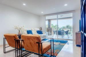 una sala de estar con un sofá y una mesa en The Elegance of Oasis -3BR Apartment Beach Front, en Palm-Eagle Beach