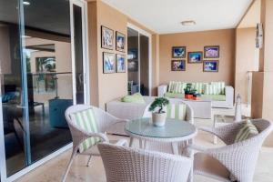 una sala de estar con una mesa y sillas en The Elegance of Oasis -3BR Apartment Beach Front, en Palm-Eagle Beach