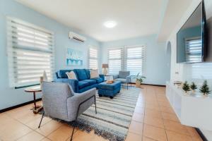 a living room with a blue couch and chairs at Comfortable house in tierra del sol resort & golf in Palm-Eagle Beach