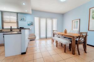 a kitchen and dining room with a wooden table and chairs at Comfortable house in tierra del sol resort & golf in Palm-Eagle Beach