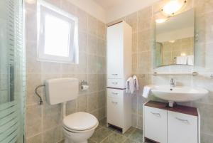 a bathroom with a toilet and a sink at Apartments and Rooms Michaela in Fažana +28 photos