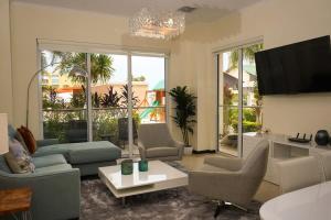 een woonkamer met een bank en stoelen en een tv bij Spectacular apartment in levent eagle beach in Palm-Eagle Beach