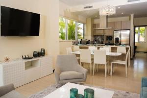 een keuken en een woonkamer met een tafel en stoelen bij Spectacular apartment in levent eagle beach in Palm-Eagle Beach