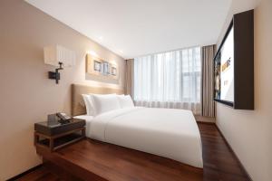 Uma cama ou camas num quarto em SSAW Hotel Chongqing Great World Jiefangbei