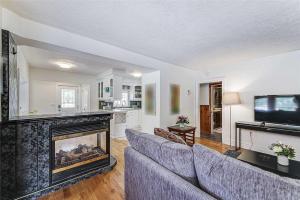 a living room with a couch and a fireplace at Cozy Cottage Retreat: HotTub, PingPong/Pool Table, Heated Pool, Fireplace in Penetanguishene