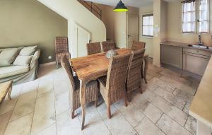 a dining room table with wicker chairs and a couch at Lovely Home In Stlaurent-De-La-Cabr in Saint-Laurent-de-la-Cabrerisse