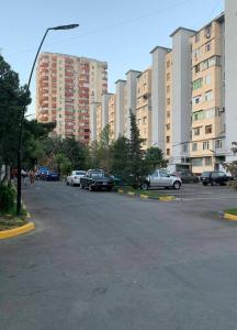 Apartment at Hasan Aliyev في باكو: موقف للسيارات مع وقوف السيارات أمام المباني الطويلة