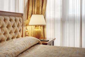 Postel nebo postele na pokoji v ubytování Borgo Palace Hotel