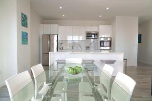 a kitchen with a glass table and white cabinets at Spectacular apartment in palm beach THE COVE in Palm-Eagle Beach