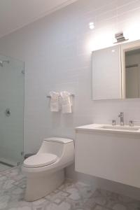 a white bathroom with a toilet and a sink at Spectacular apartment in palm beach THE COVE in Palm-Eagle Beach