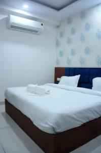 sypialnia z dużym białym łóżkiem i oknem w obiekcie Hotel Ganga Amrit Haridwar Near Railway Station w mieście Haridwar